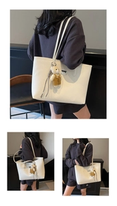 Detail of minimalist cream tote bag with lychee texture and cute bear plush charm