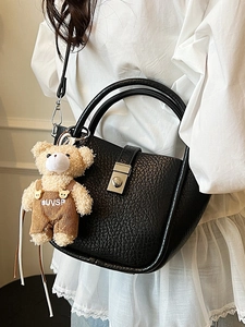 Minimalist black lychee leather bucket bag with silver clasp and cute plush bear charm