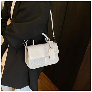 Détail montrant la texture tissée et la poignée nouée du sac à bandoulière gris clair