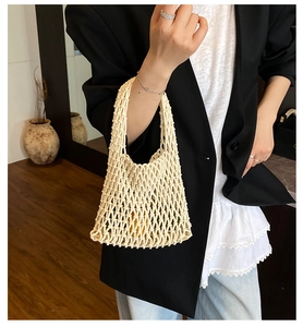 Détail du sac cabas en maille tressée crème porté avec une tenue de bureau élégante et chic