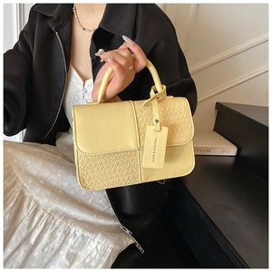 Détail du sac carré jaune fromage avec texture crocodile et étiquette de mode