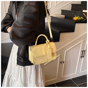 Détail du sac à main jaune clair avec panneaux en cuir lisse et textures tissées