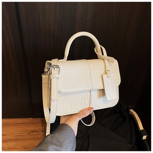 Détail du sac en cuir blanc crème avec texture tressée et étiquette de mode