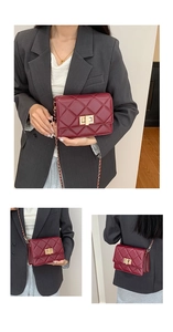 Détail du sac matelassé bordeaux avec fermoir pivotant doré et texture en cuir