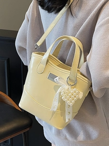 Minimalist cream yellow leather bucket bag with lace bow and pearl heart charm accessory