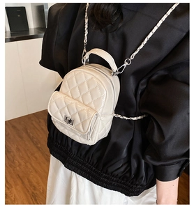 Detail eines Mini-Rucksacks in Creme mit Steppmuster, Silberkette und Metallverschluss