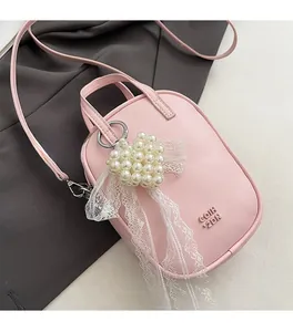 Dettaglio borsa in pelle PU rosa con logo GOIH 2DN e ciondolo a cuore in perla e pizzo