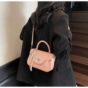Detail view of pink leather crossbody bag with decorative scarf on a model