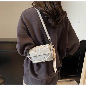 Crossbody view of grey woven square bag with marble texture and colorful rope tassels