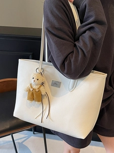 White faux leather tote bag with lychee texture and cute teddy bear charm on shoulder