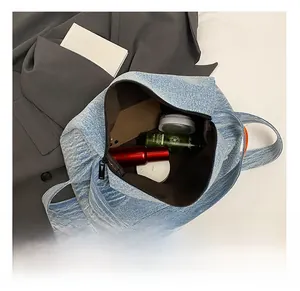Vista dall'alto della borsa in denim con spazioso interno marrone per trucchi e cellulare