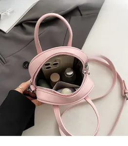 Dettaglio dell'interno spazioso e delle cuciture di una mini borsa a tracolla rosa