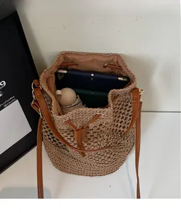 Macro detail of hollow woven straw bucket bag showing spacious interior and drawstring