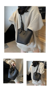 Detail of black lychee grain leather bucket bag with metal buckle and shoulder strap