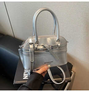 Silver shell-shaped Boston bag featuring top handle and adjustable crossbody strap
