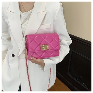 Vue détaillée du sac matelassé fuchsia avec chaîne dorée et fermoir rotatif métallique