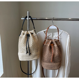 Detail of woven straw bucket bag with leather drawstring and matching shoulder strap