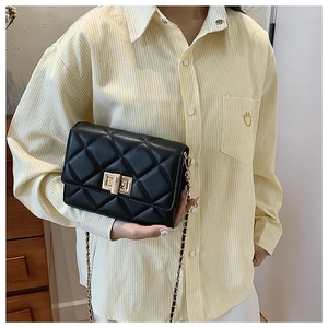 Détail du sac à bandoulière matelassé noir avec fermoir doré et bandoulière chaîne