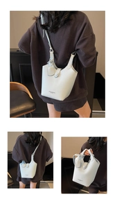 Detailed view of light blue lychee pattern bucket bag with strap and logo brand detail