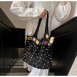Detail of black crochet tote bag featuring colorful embroidery and beaded accents