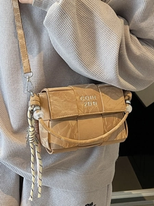 Brown woven crossbody bag with top handle and logo detail for casual fashion look