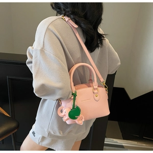 Pink lychee texture bucket bag detail with elephant charm and FASHION & BAGS logo
