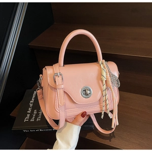 Detail of pink faux leather satchel showing silver twist lock and silk scarf accent