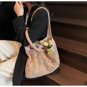 Detail of crochet knit tote bag with floral bead accents and intricate mesh texture