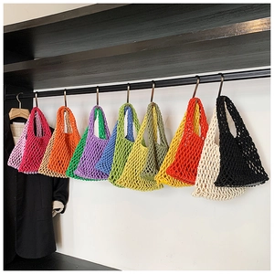 Sacs cabas colorés en maille crochetée suspendus en neuf couleurs acidulées sur un présentoir
