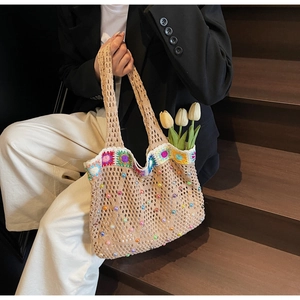 Detailed close-up of knit tote bag featuring crochet sunflowers and colorful pearl beads