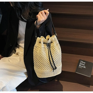 Detail of hollow woven texture with black leather drawstring and metal buckle