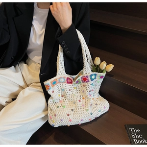 Detailed macro of white crochet tote bag with colorful beads and floral Granny Square pattern