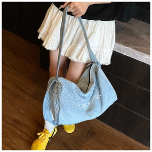 Dettaglio della borsa tote in denim azzurro con tracolla larga e stampa grafica OSJL JON