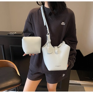 Detail of light blue pebble leather bucket bag and pouch with metal buckle closure
