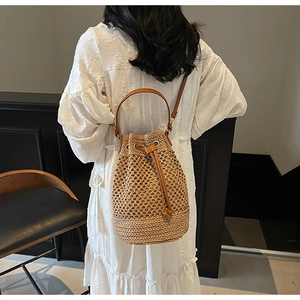 Detail showing woven bucket bag texture with drawstring closure and leather shoulder strap