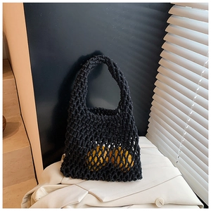 Détail du sac à main en maille noire tissée à la main avec motif de tricot ajouré