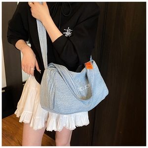 Dettaglio della borsa tote in denim azzurro con logo SOJO bianco ed etichetta arancione
