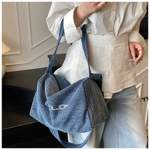 Dettaglio della borsa tote in denim blu con scritta BOLJON bianca e tracolla larga