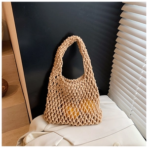 Gros plan sur un sac cabas en crochet beige avec des motifs en maille de losange