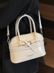 Elegant cream shell-shaped crossbody bag with polished synthetic leather and metal hooks