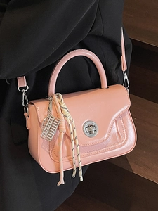 Pink glossy vintage faux leather crossbody bag with silver twist lock and woven charm