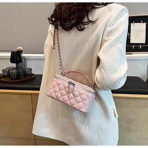 Detail of pink quilted vanity bag with metal chain strap and dual zipper closure