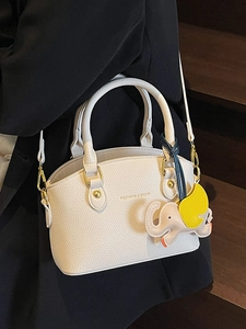 Minimalist beige pebble leather bucket bag with elephant charm and gold hardware for women