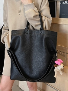 Elegante bolso tote negro de cuero sintético con un lindo colgante de cachorro y correa