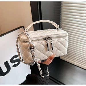 Detail of white quilted texture leather box bag with silver ball chain and top handle
