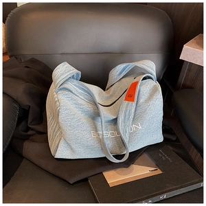 Dettaglio della borsa tote in denim azzurro con stampa BCSOLOON ed etichetta arancione