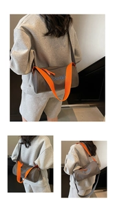Detail view of grey cylinder tote bag with orange strap and '19 EST 85' embroidery