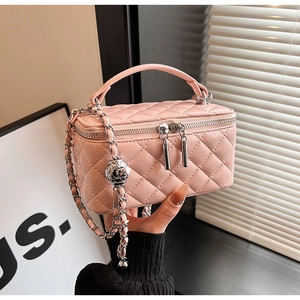 Close-up of pink quilted leather box bag with silver chain and metal adjustment ball