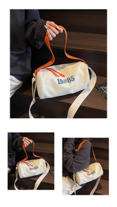Detail view of canvas barrel bag with blue embroidery and orange zipper accents
