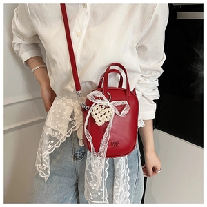 Mini borsa rossa a tracolla con fiocco in pizzo e ciondolo a cuore di perle